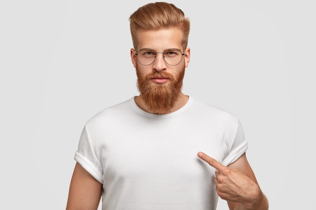 Attractive young man with red haircut and beard, points at blank t shirt