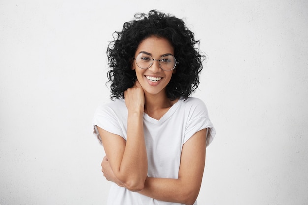 Attractive young mixed race woman with charming smile wearing trendy eyeglasses