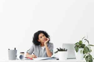 Free photo attractive young pensive woman engineer wearing grey shirt over white top looking up