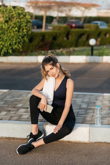 Attractive young sportive woman chilling on street outside in sunny morning. Training, summer time, fitness, workout, fashionable model, healthy lifestyle, motivation