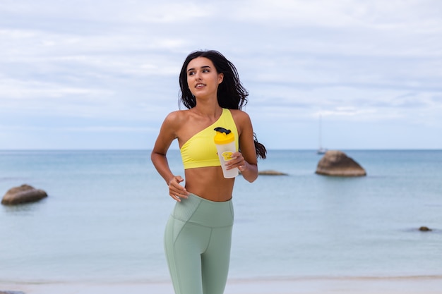 Attractive young woman in colorful sport wear on beach