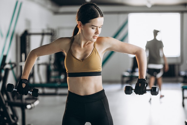 Foto gratuita giovane donna attraente che si esercita in ginnastica