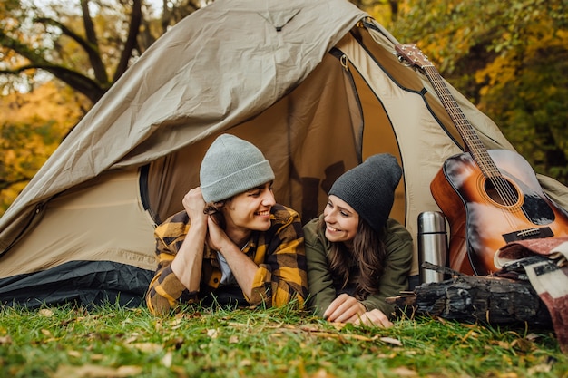 Free photo attractive young woman and handsome man lying in the tent