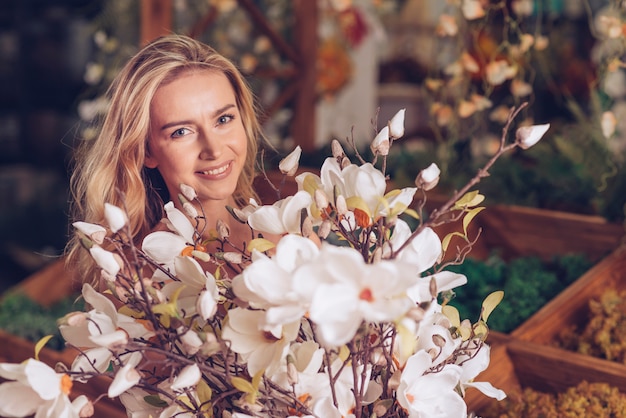 Foto gratuita una giovane donna attraente che tiene il mazzo del fiore bianco