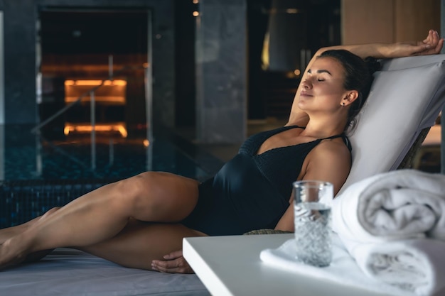 Attractive young woman is relaxing in a spa complex with a sauna