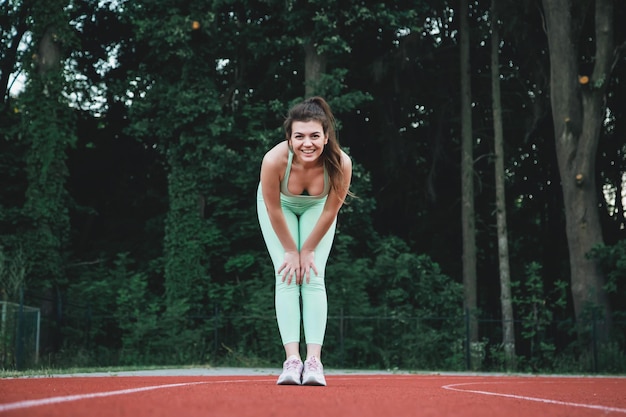 Free photo attractive young woman jogging in the stadium