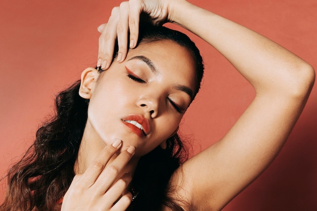 Attractive young woman playing with hands around her face