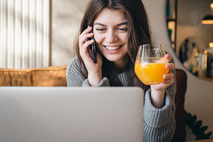 無料Photo 電話で話し、ラップトップで作業する魅力的な若い女性