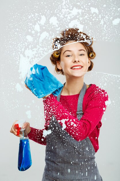 Attractive young woman washes windows