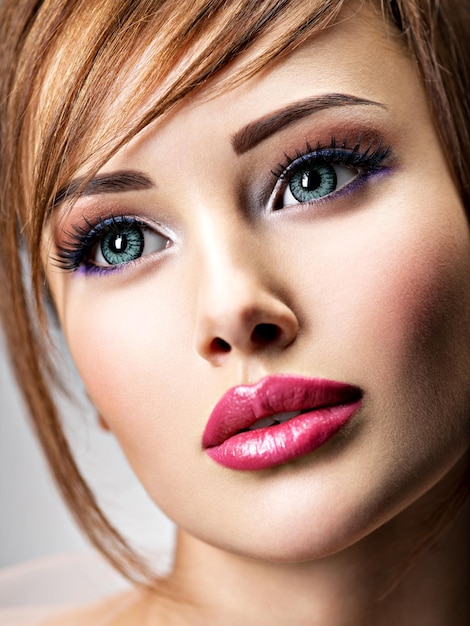 Привлекательная молодая женщина с красивыми большими голубыми глазами. Крупным планом лицо удивительной девушки с сексуальными губами.