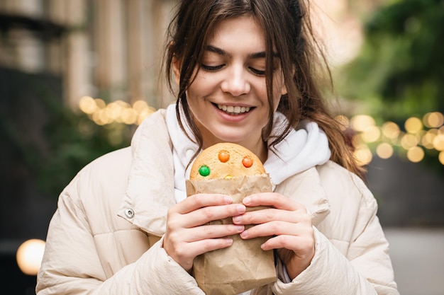 Foto gratuita giovane donna attraente con un bel pan di zenzero durante una passeggiata