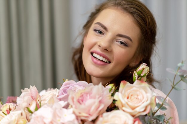 Attractive young woman with bouquet of hundreds of flowers is spending time at home.