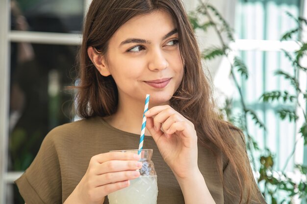 暑い夏の日にレモネードのグラスを持つ魅力的な若い女性