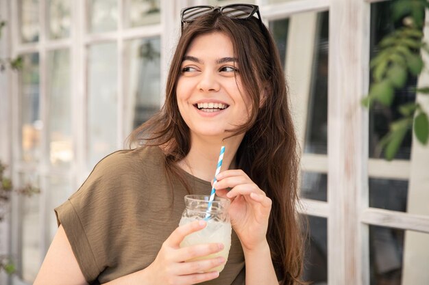 暑い夏の日にレモネードのグラスを持つ魅力的な若い女性