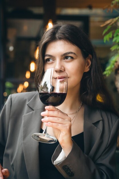 レストランでグラスワインを持つ魅力的な若い女性