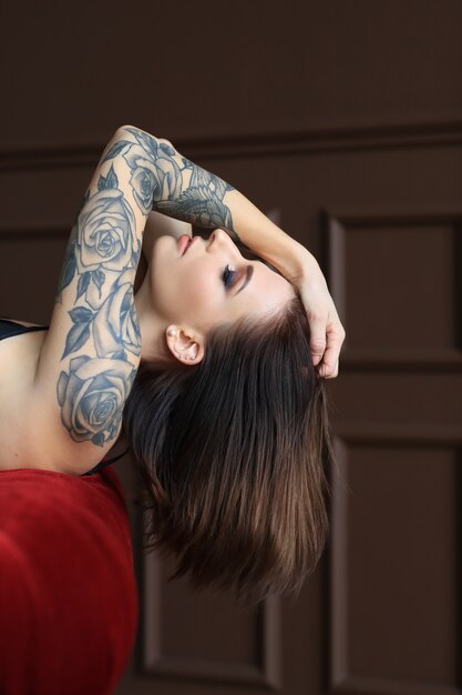 タトゥーのポーズを持つ魅力的な若い女性