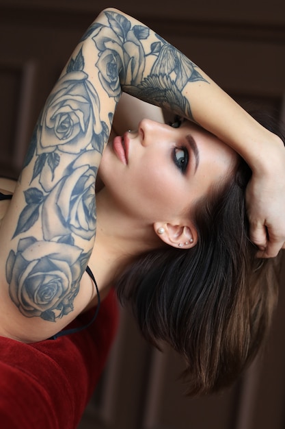 Foto gratuita giovane donna attraente con la posa del tatuaggio