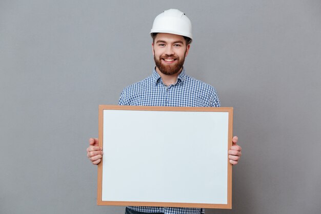 Attractve bearded builder holding blank board