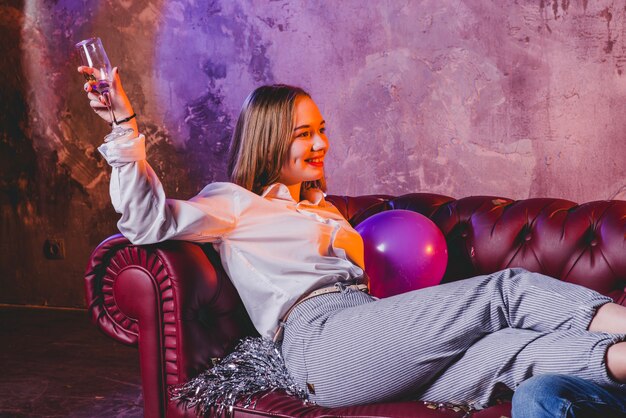Привлекательная женщина на диване с шампанским