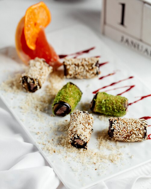 Aubergine wraps encrusted with sesame and green sprinkles