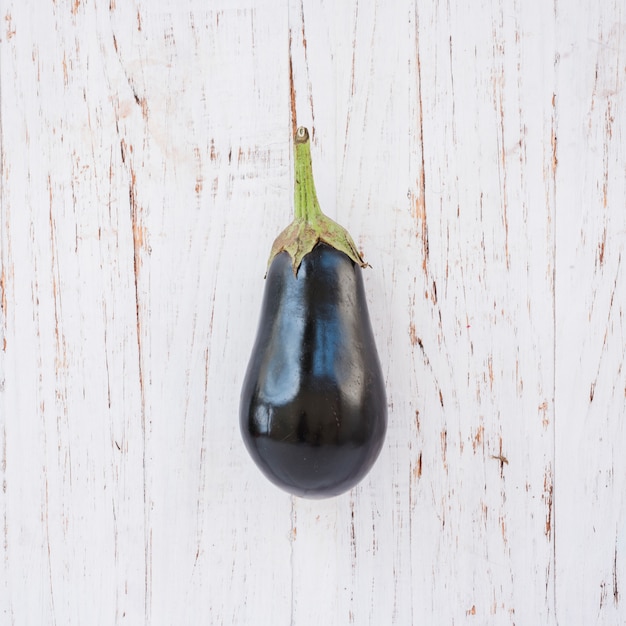 Aubergines on white wooden textured backdrop