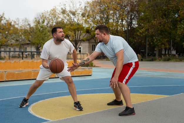 無料写真 プラスサイズの男性がバスケットボールをしている本物のシーン