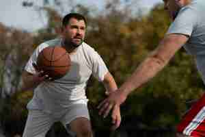 Foto gratuita scene autentiche di maschi di taglia plus che giocano a basket