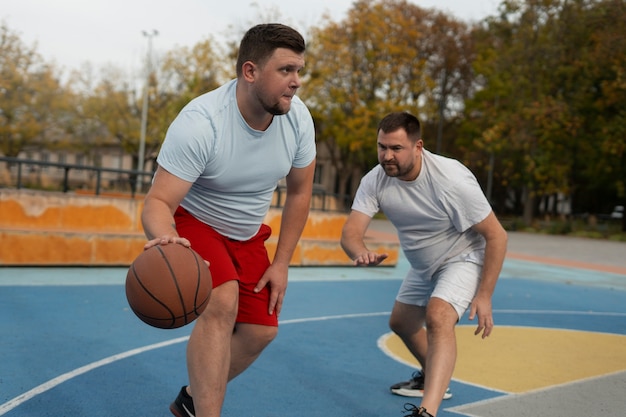 Foto gratuita scene autentiche di maschi di taglia plus che giocano a basket