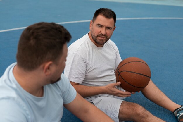 プラスサイズの男性がバスケットボールをしている本物のシーン