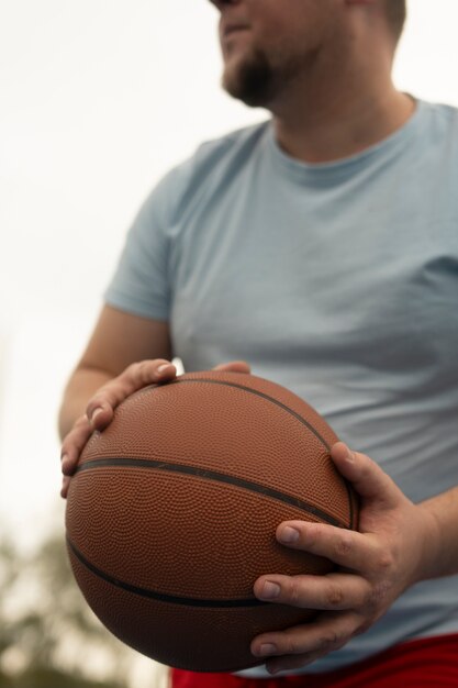 プラスサイズの男性がバスケットボールをしている本物のシーン