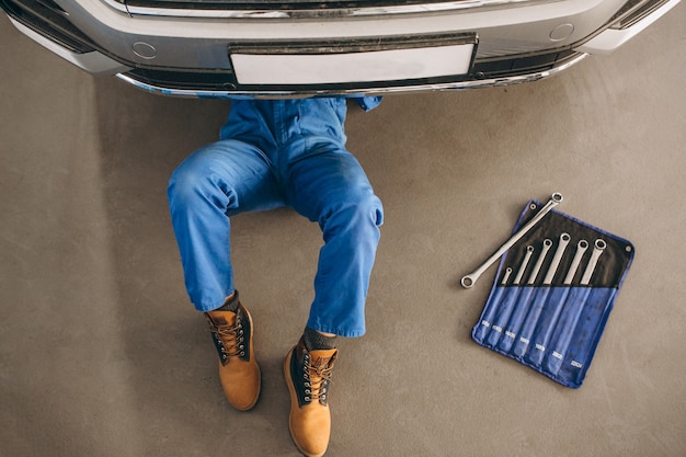 Auto mechanic checking car