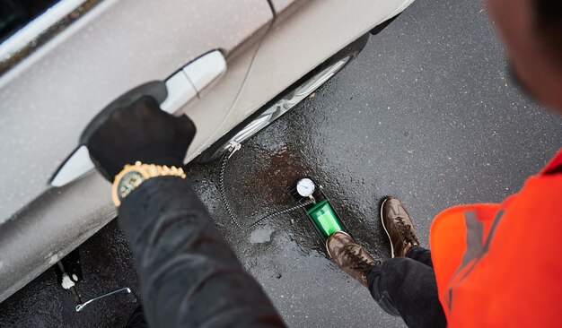 Auto mechanic inflating tire with air compressor on the street