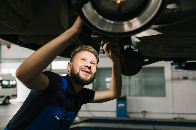 Free photo auto mechanic looking car's bilge