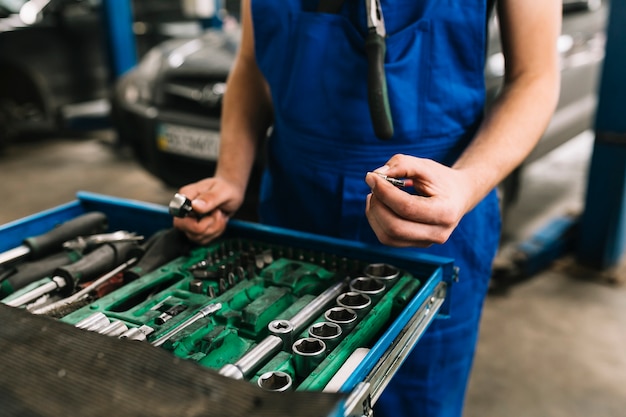 Auto mechanic's hand holding spanners