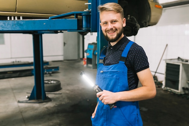 Auto mechanic standing near locklift