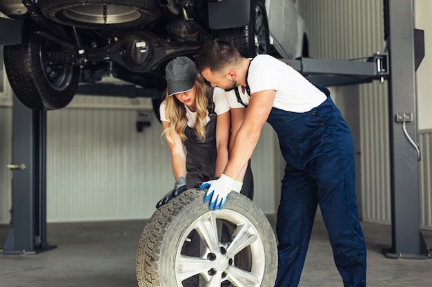 Auto service employees pushing wheel