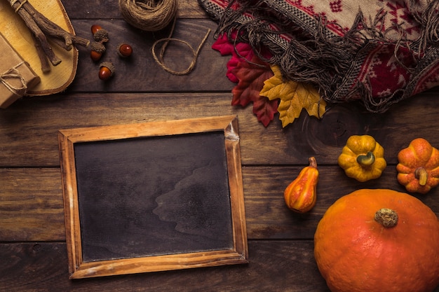 Free photo autumn arrangement with chalkboard frame