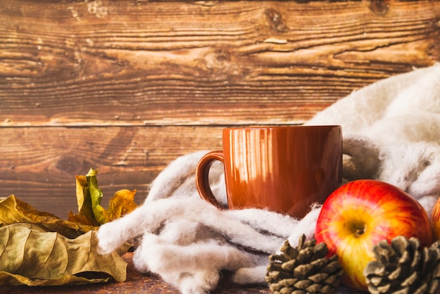 Autumn arrangement with warm scarf and mug