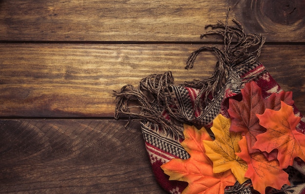 Autumn composition of warm scarf and leaves