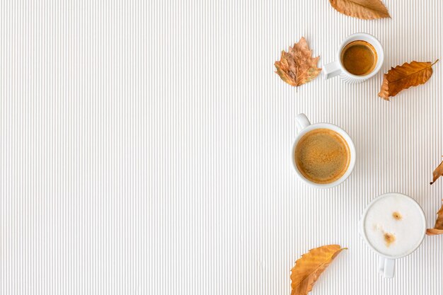 一杯のコーヒーと白い背景の上の葉秋のコンポジション