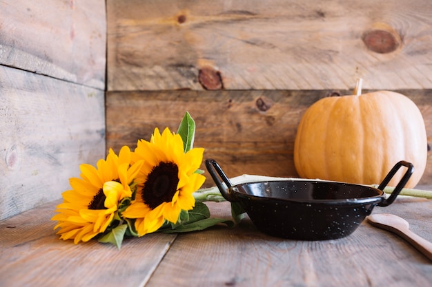 Autumn composition with pan and sunflowers