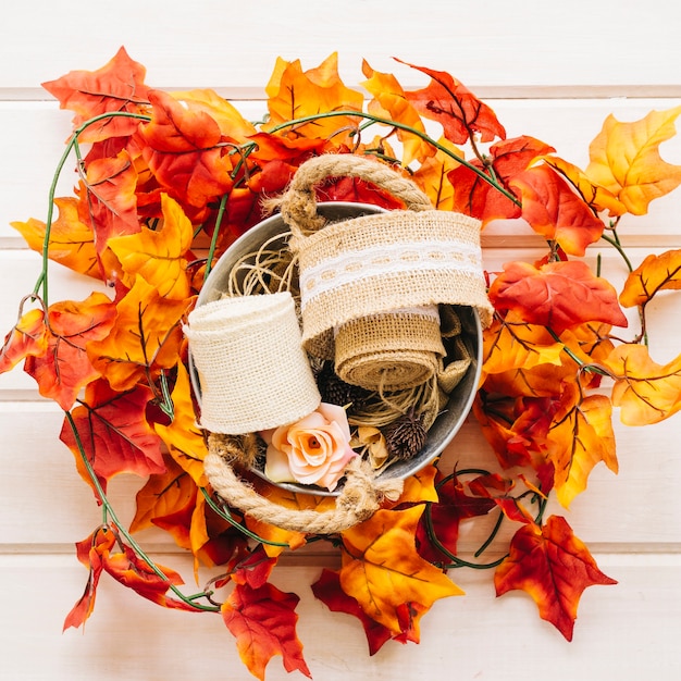 Free photo autumn decoration with basket on autumn leaves