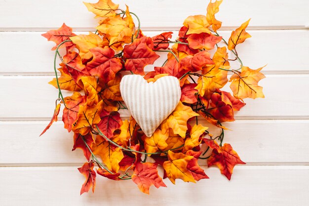 Autumn decoration with heart on autumn leaves