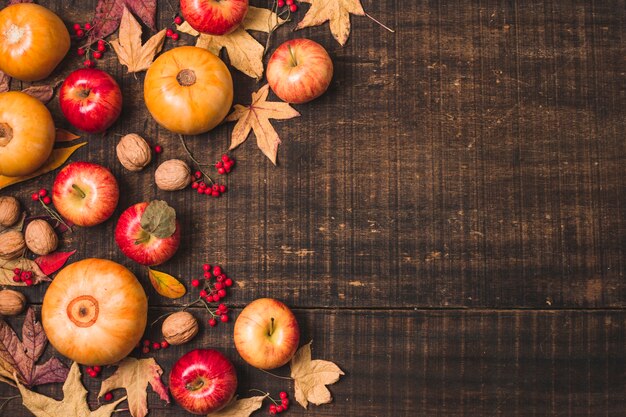 Autumn fruit and leaves on wooden background