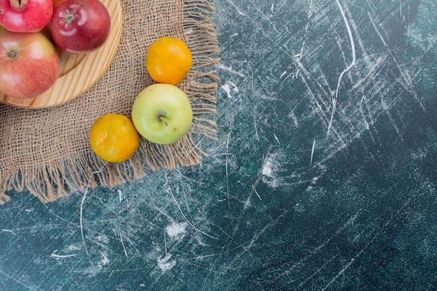 Autumn fruits in a platter on blue background. 