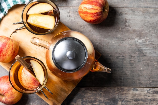 Autumn hot apple drink with spices on wooden table