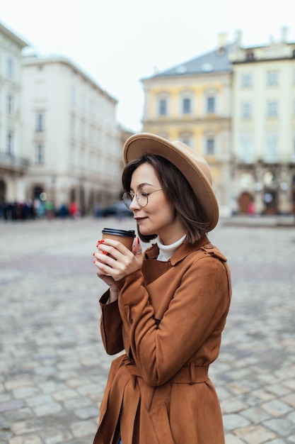 Autumn lady drinking coffee on autumn city