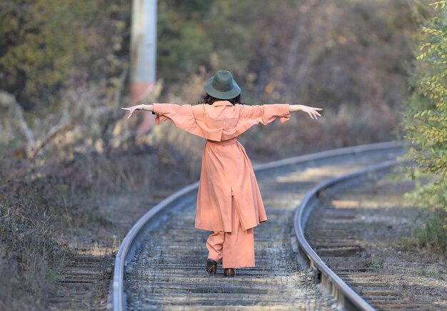Autumn portrait of fashion model on railway rails