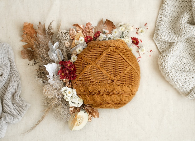 Foto gratuita autunno natura morta con fiori ed elementi lavorati a maglia su uno spazio bianco si chiuda.