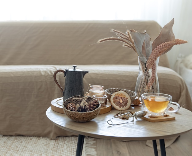 Autumn still life with tea on the table in the interior of the room, copy space.